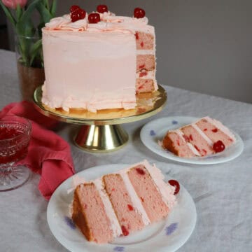 Maraschino Cherry Cake layers with a pink cherry frosting cake slice on white English bone china
