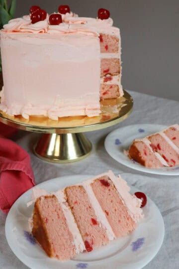 Maraschino Cherry Cake layers with a pink cherry frosting cake slice on white English bone china