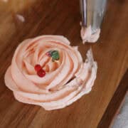 pink cherry frosting piped into a rosette with a cherry ring on display