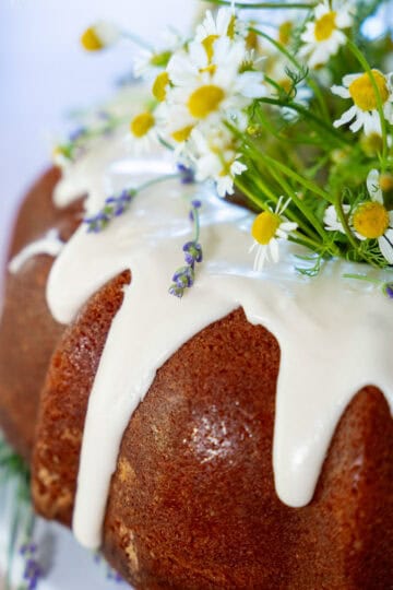 Vanilla Bundt Cake with vanilla glaze and delicate white and yellow flowers